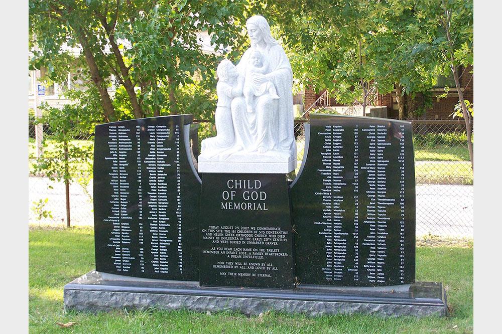 Black granite civic memorial with full round religious sculpture