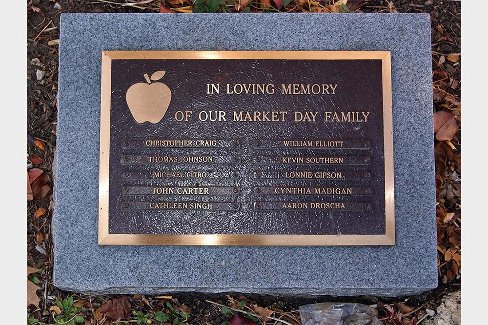 Bronze plaque with custom emblem of apple and list of names on granite base