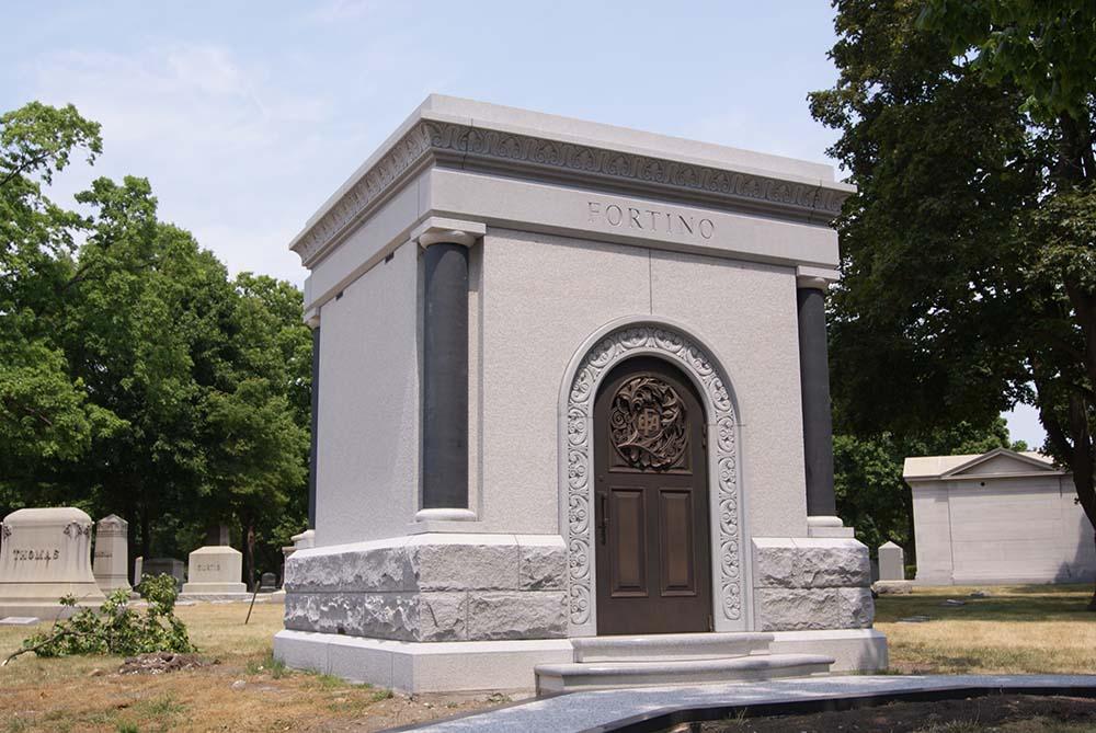 Private mausoleum with custom molding bronze door and granite sidewalk