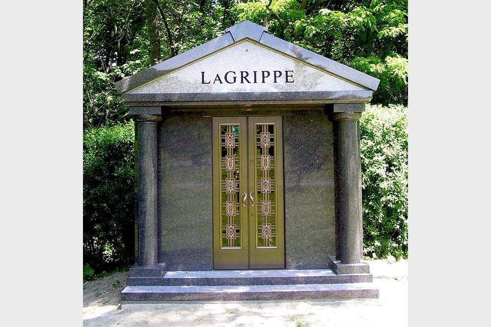 Private walk-in mausoleum with columns and ornate gold door