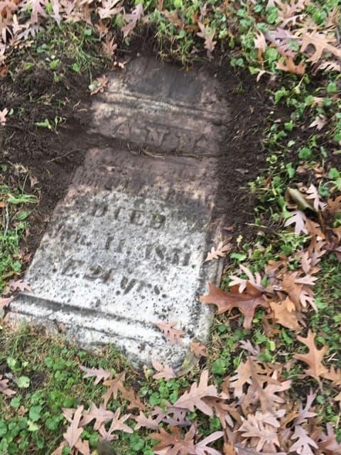 Upright monument dug into ground in need of repair