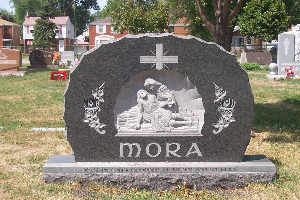 Family monument in dark gray granite with Christian figures and Spanish verse