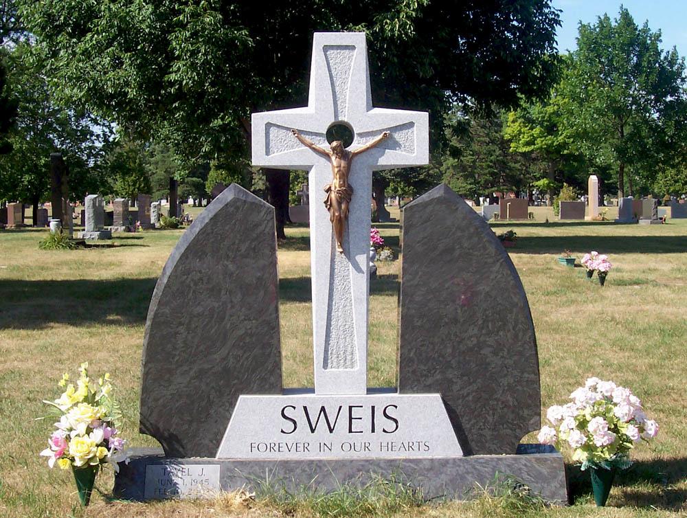 Family monument in multiple granite colors with bronze Jesus on a granite cross