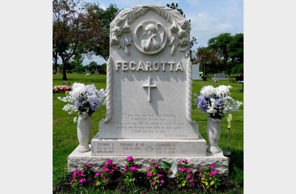 Traditional family monument with carved angel and flowers