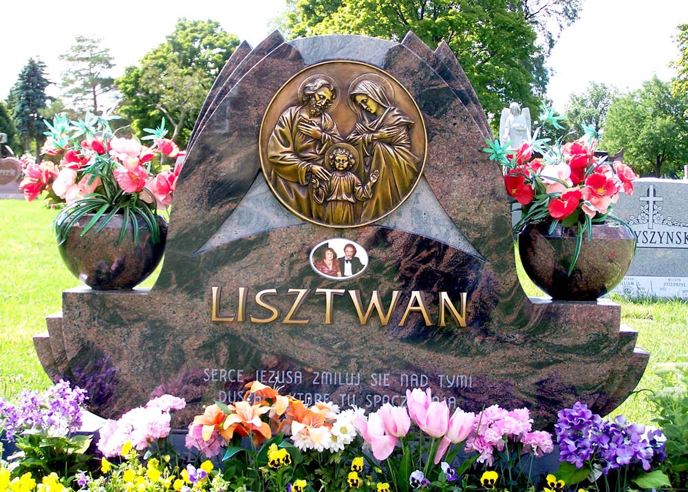 Family monument in variegated granite with bronze appliqué of the Holy Family and Polish lettering